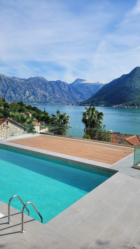 A serene infinity pool with a stunning view of a mountainous bay under a clear sky, ideal for relaxation.